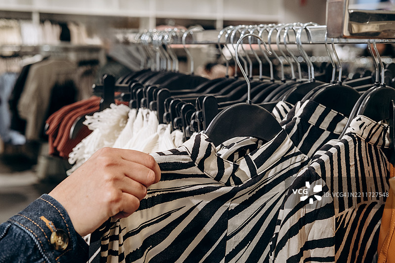 时尚服装和配饰精品店内挂着不同款式的衣服图片素材