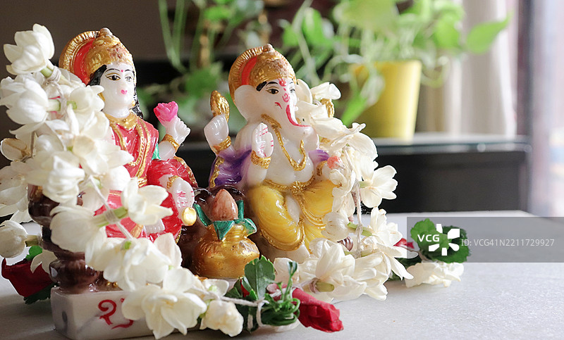 装饰着茉莉花和摩卡花环的拉克希米女神和甘尼许雕像/偶像/卡拉什罐 / 排灯节 / 深阿瓦利节 / 丹特拉斯节图片素材