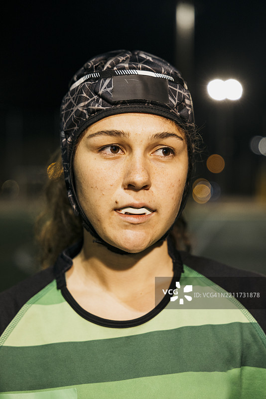 专注的橄榄球运动员在夜间佩戴保护头盔和护齿器图片素材