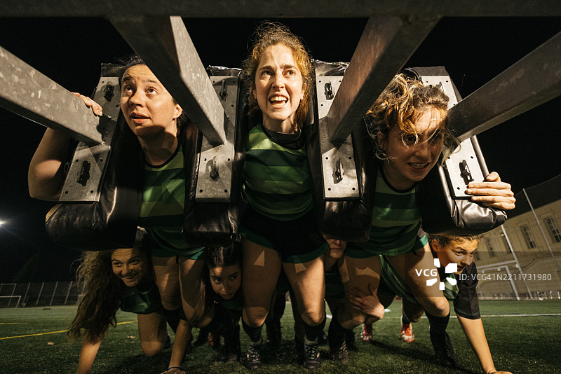 女子橄榄球队在夜间进行力量与体能训练图片素材