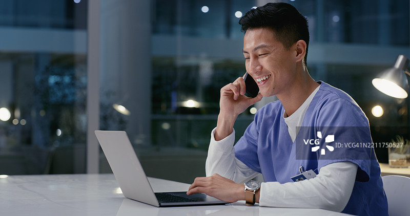 电话会议，男士与医生在医院进行夜班远程医疗咨询，使用笔记本电脑。计算机，加班和男性外科实习生在手机上讨论患者治疗方案。图片素材