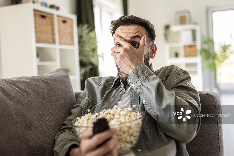 男人观看惊悚片时惊恐的表情图片素材