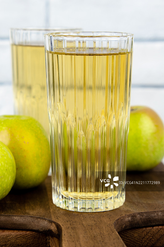 两杯苹果汁和绿色苹果。图片素材