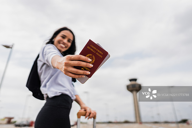 女人在机场停车场展示她的护照图片素材