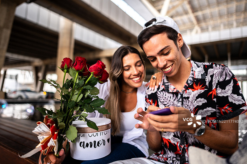 年轻情侣在机场使用手机图片素材