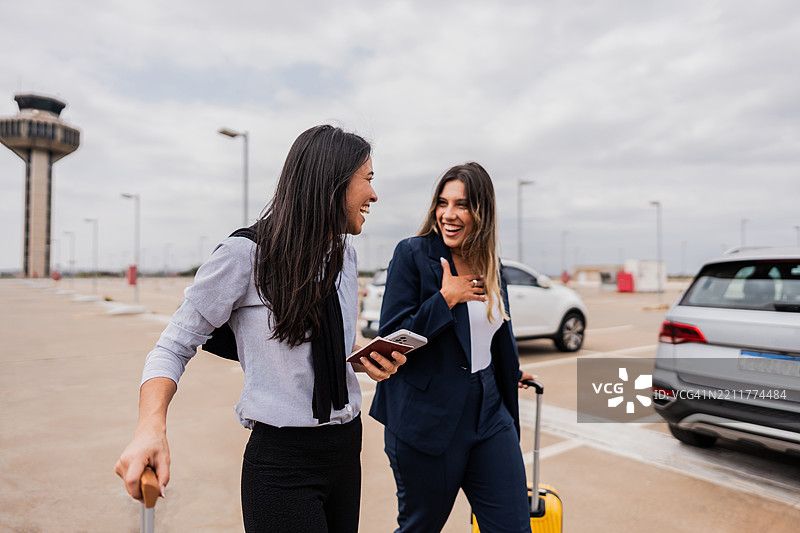 同事们在机场停车场边走边交谈图片素材