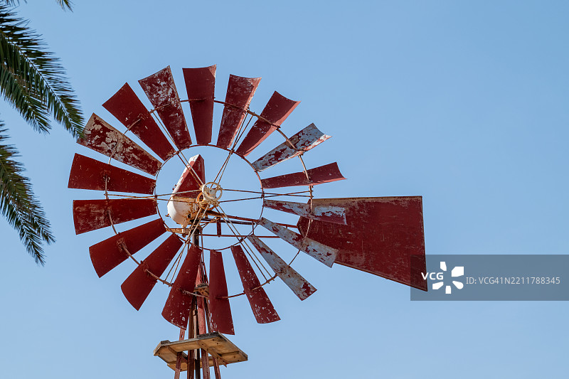福特文图拉的红色风车，漆面剥落，背景是晴朗的蓝天图片素材