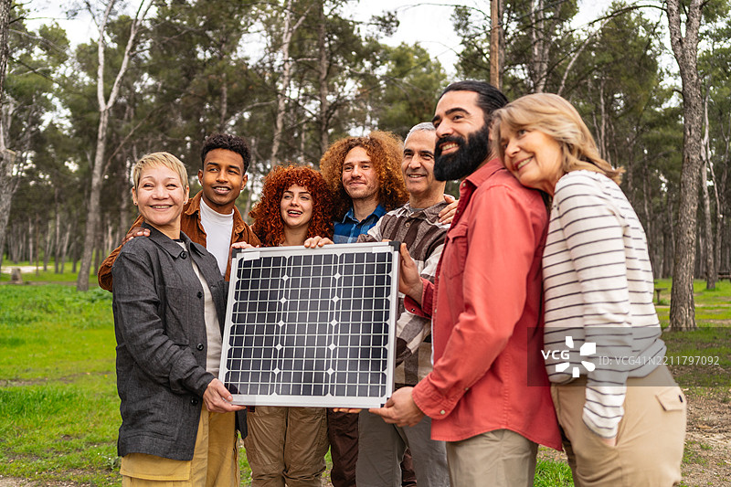环保人士在郁郁葱葱的森林中展示太阳能电池板，象征着对清洁能源的承诺和生态合作。图片素材