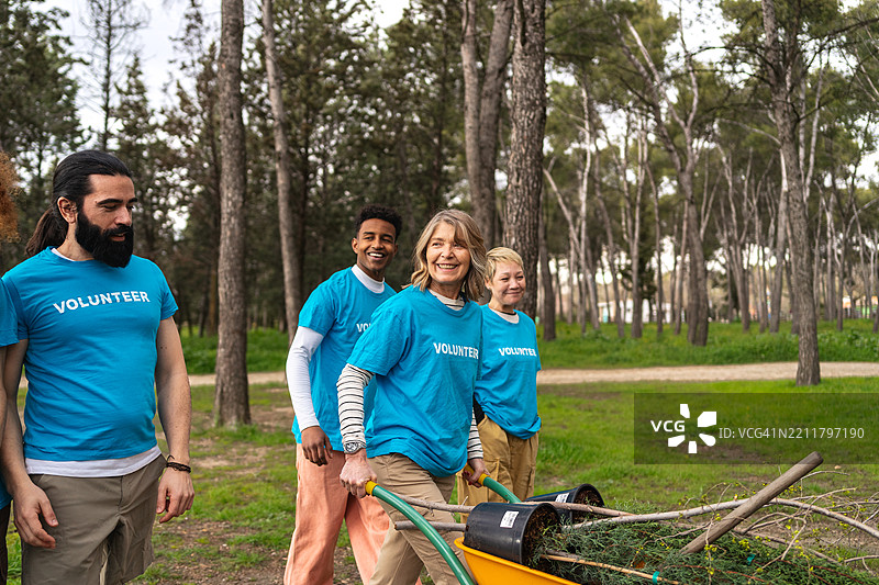 社区志愿者在城市公园植树，合作恢复绿色景观，改善当地生态系统图片素材