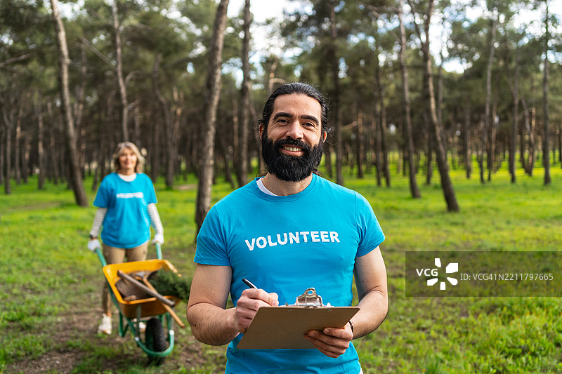 森林保护志愿者收集垃圾，协作进行环境清理工作图片素材