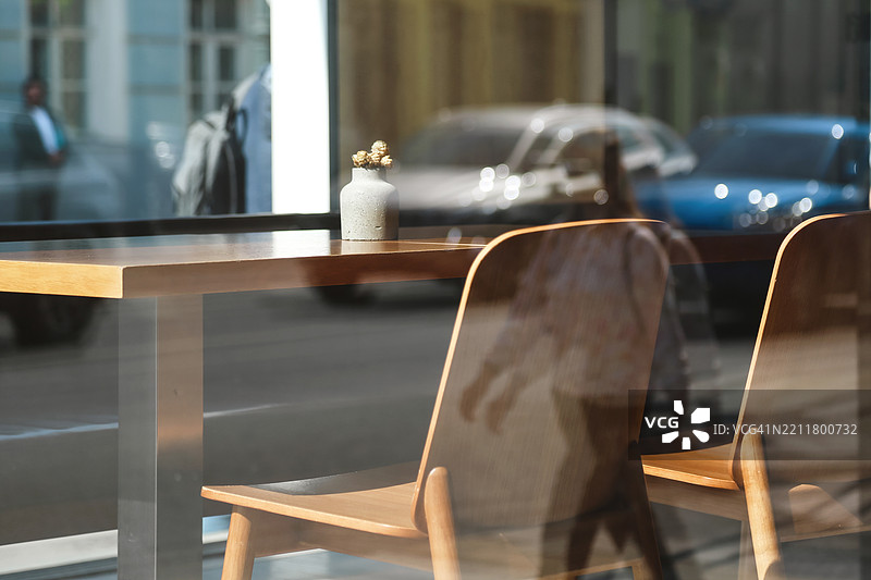空荡荡的人行道咖啡馆，木桌和优雅的装饰细节，背景是模糊的城市街道。图片素材