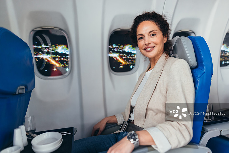 商务女性在头等舱夜间飞行中微笑图片素材