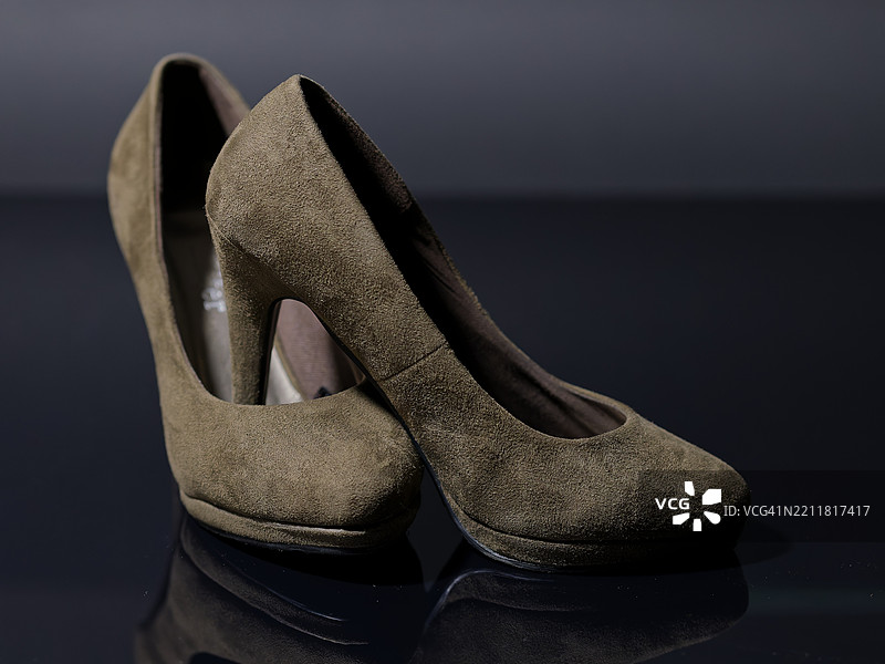 黑色背景下桌子上的鞋子特写图片素材