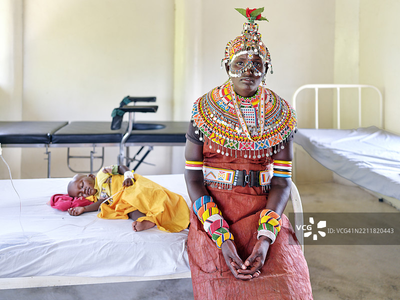 桑布鲁母亲坐在医院病床旁陪伴生病的孩子图片素材