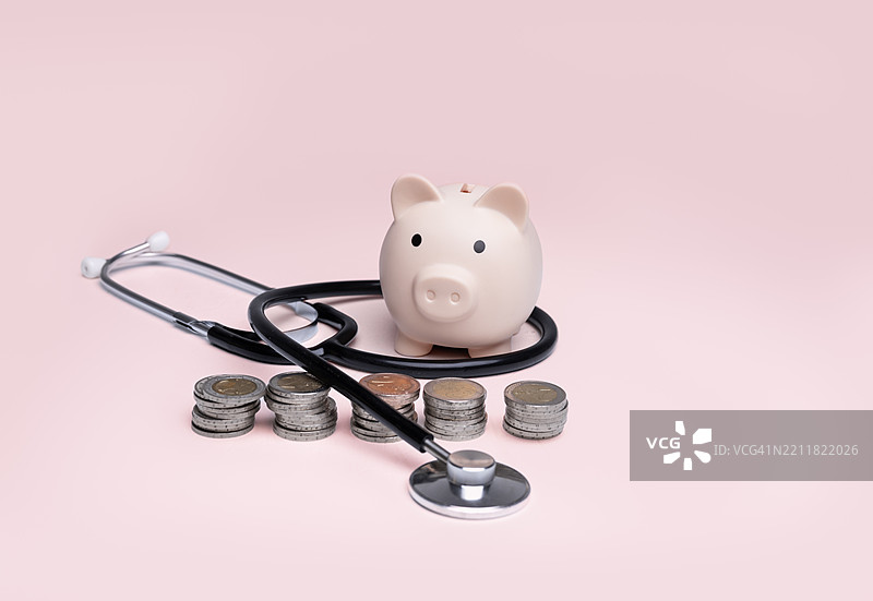 储蓄罐里装着硬币和听诊器，健康保险与储蓄概念，健康与财富，储蓄与宠物保险，健康保险，宠物健康保险图片素材