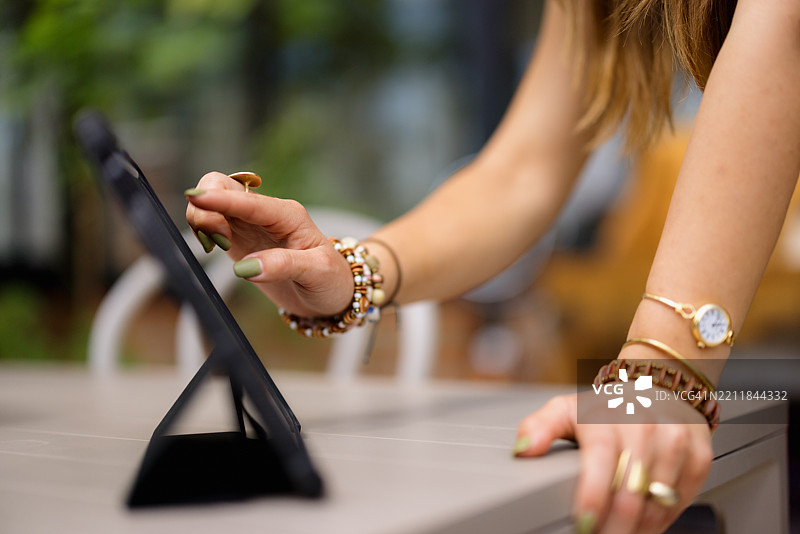 女性在户外咖啡馆使用平板电脑浏览互联网图片素材