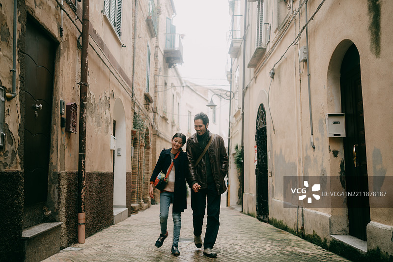 父亲和小女儿在意大利阿布鲁佐的基耶蒂老街上散步图片素材