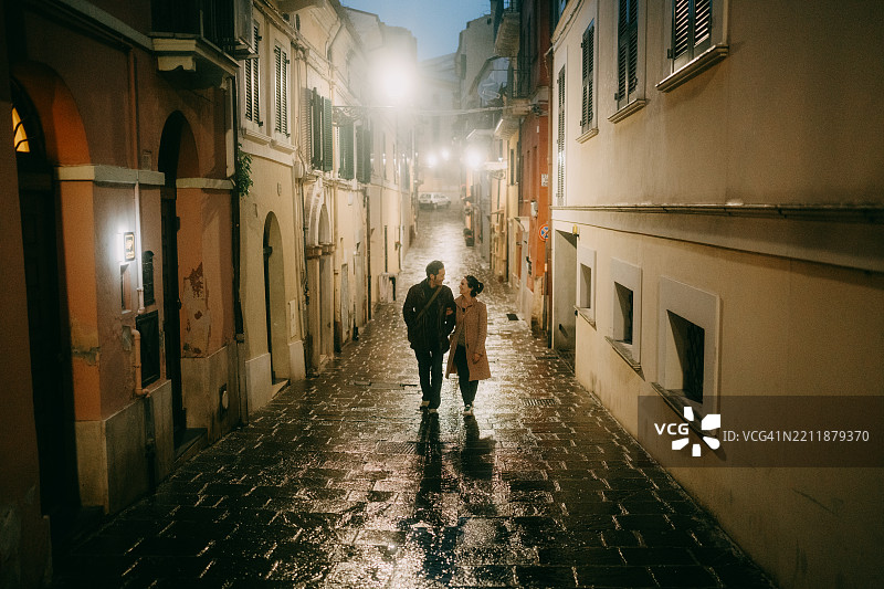 在意大利夜晚街头散步的游客情侣图片素材