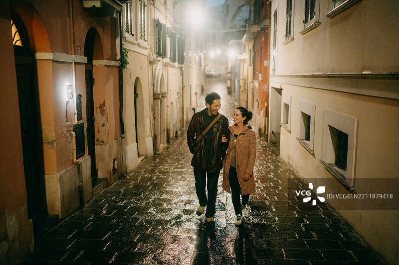 情侣在意大利古镇夜间散步图片素材