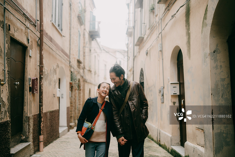 父亲和年轻女儿在意大利阿布鲁佐的基耶蒂老街上散步图片素材
