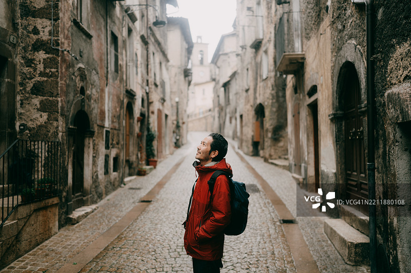 男子在意大利阿布鲁佐的斯卡诺中世纪街道上享受时光图片素材