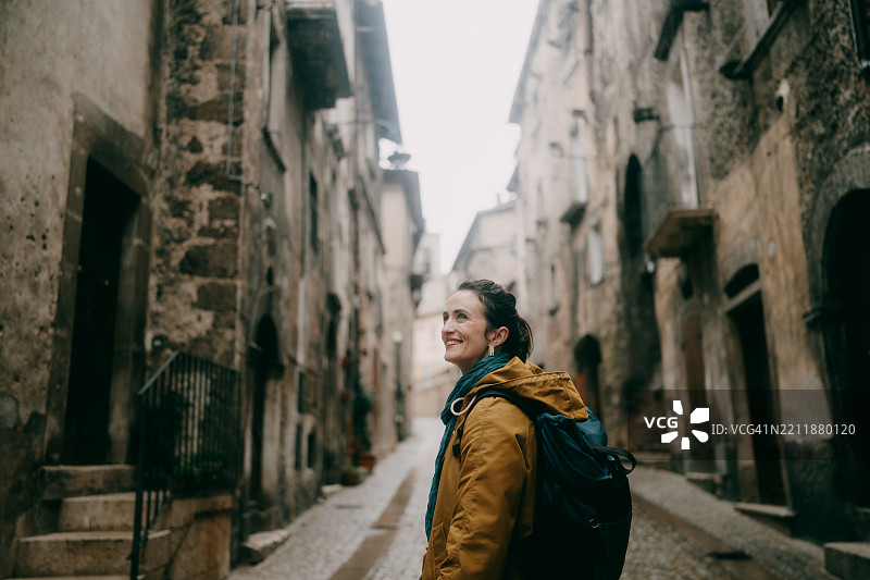 女人在意大利阿布鲁佐的斯卡诺中世纪街道上享受时光图片素材