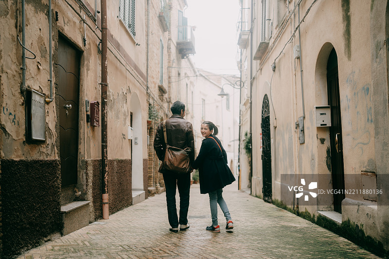 父亲和年轻女儿在意大利阿布鲁佐的基耶蒂老街散步图片素材
