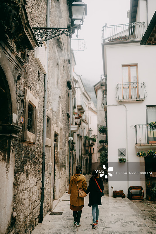 母亲和小女儿在意大利阿布鲁佐的帕琴托村散步图片素材