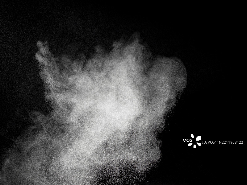 黑色背景上，白色粉末烟雾向上升起的爆炸。图片素材