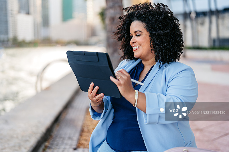 中年非裔美国女性商务人士在迈阿密市中心的码头上使用素描本图片素材