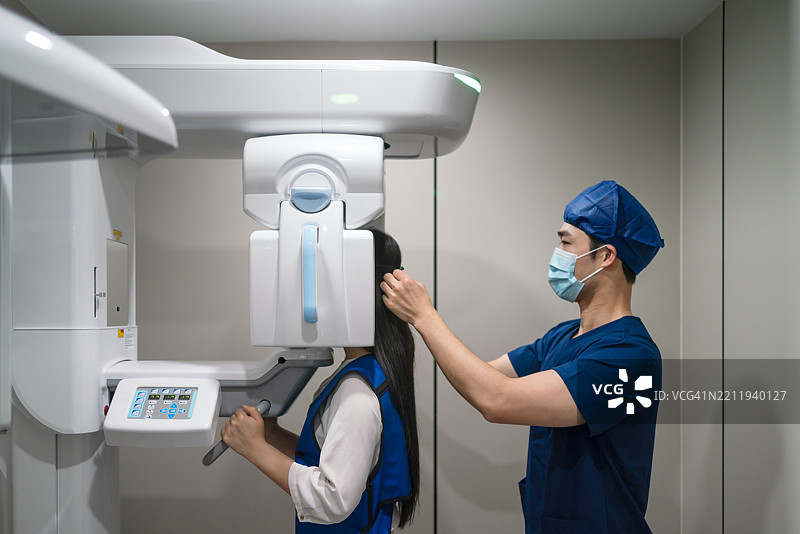 亚洲男性护士在医院为女性患者准备CT扫描。图片素材