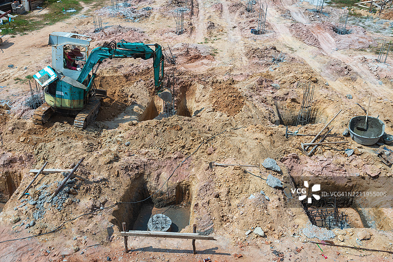 挖掘机正在挖掘地面，以便在灌注了钻孔桩后浇筑基础。图片素材