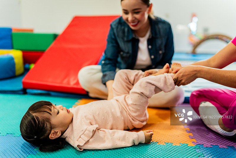 治疗师在治疗过程中为孩子拉伸腿部图片素材