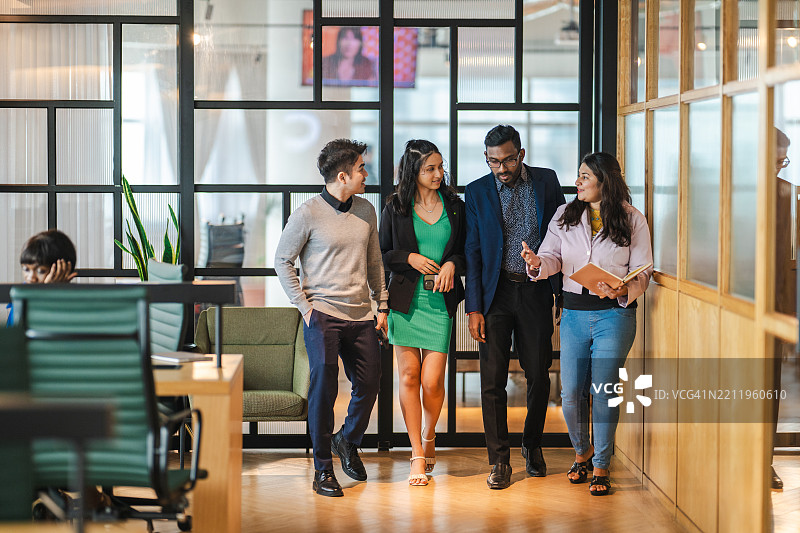 亚洲商务团队在办公室走廊中讨论图片素材