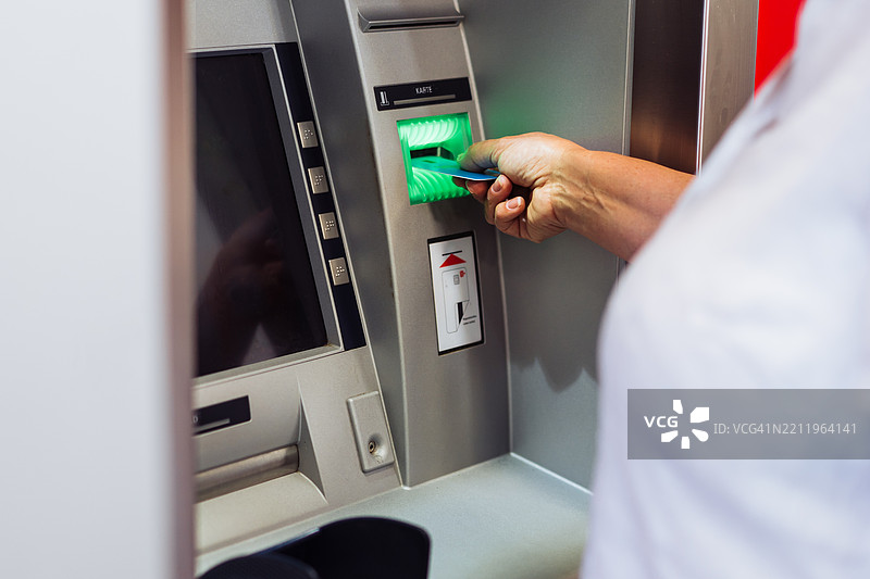 女性使用自动取款机用借记卡取款图片素材