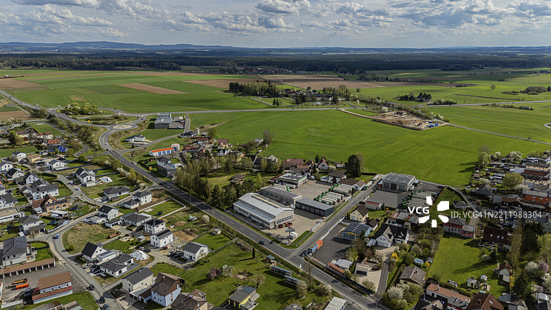 德国巴伐利亚上普法尔茨的米特泰希村庄鸟瞰图，房屋、街道和田野在略微多云的天空下。图片素材