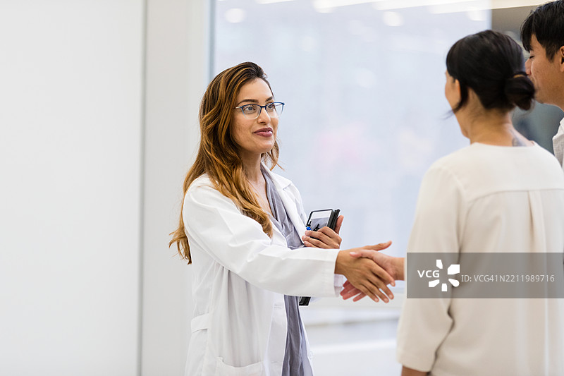 女医生在医疗办公室与患者握手图片素材
