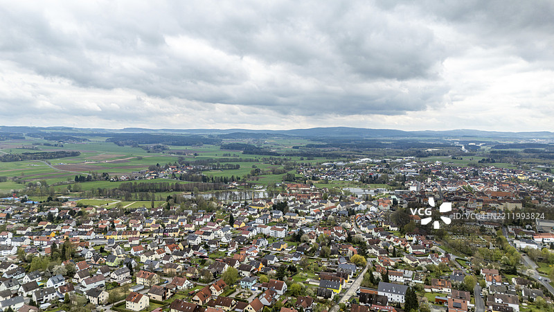 德国巴伐利亚上普法尔茨地区蒂尔申罗伊特的绿野下，云雾笼罩的小镇景观图片素材