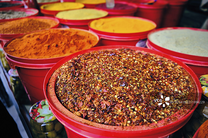 市场摊位上堆满了热辣的胡椒粒、磨碎的红椒粉、藏红花和姜黄。市场上五彩缤纷的干香料堆。图片素材