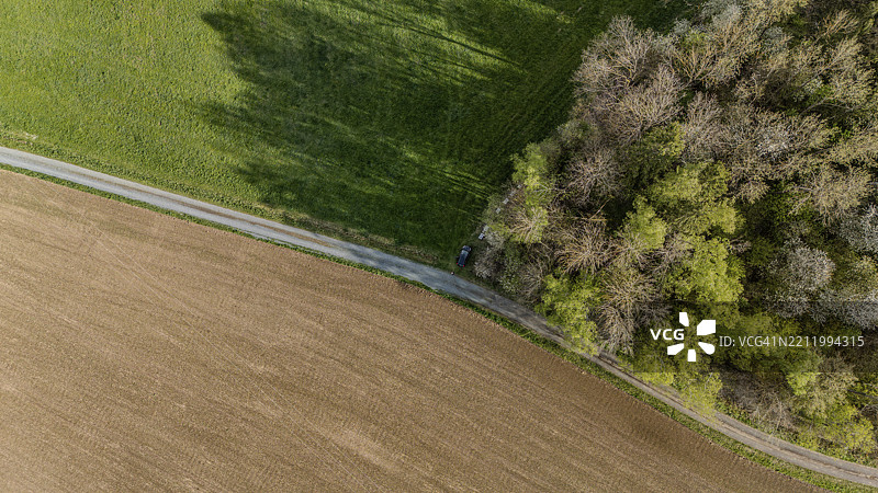 德国巴伐利亚上普法尔茨米特特海赫，郁郁葱葱的绿地间一条道路的鸟瞰图，周围是田野和林地。图片素材