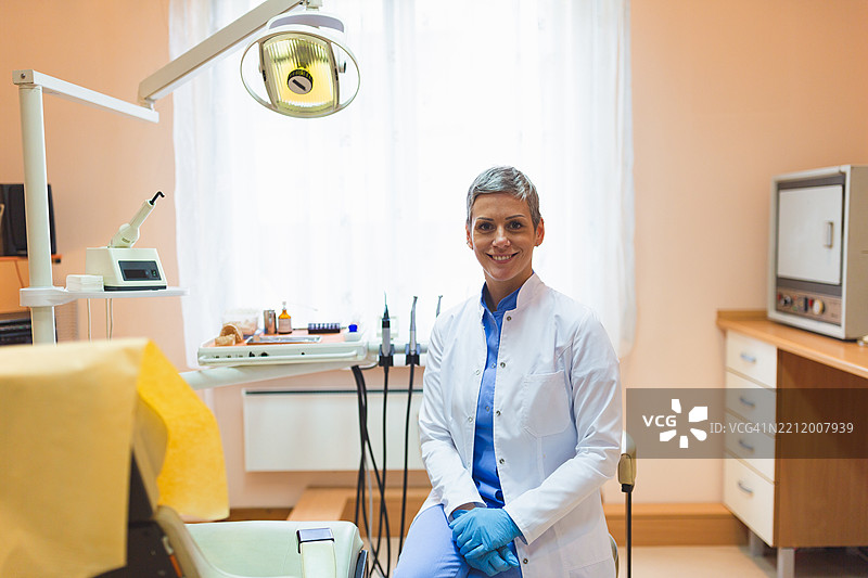 微笑的牙医在现代牙科办公室里图片素材