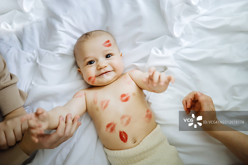 可持续育儿：妈妈亲吻穿着环保羊毛尿布的宝宝，充满爱与关怀。图片素材