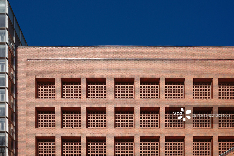 砖砌建筑的外立面，特色是方形格子窗和独特的斜楼梯。图片素材