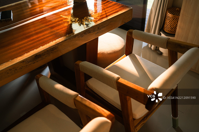 沐浴在自然阳光下的极简木椅，营造出舒适的现代室内场景。图片素材