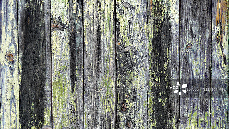 特写镜头：灰色、黑色木板墙，带有铜绿和剥落的绿色油漆。纹理粗糙。葡萄牙杜罗河谷皮尼昂。图片素材