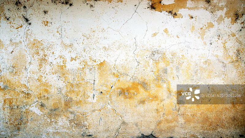 葡萄牙杜罗河谷皮尼昂,阳光下,裂纹墙壁上带有铜绿和剥落的白色与黄色油漆。粗糙的纹理,自然色彩。图片素材