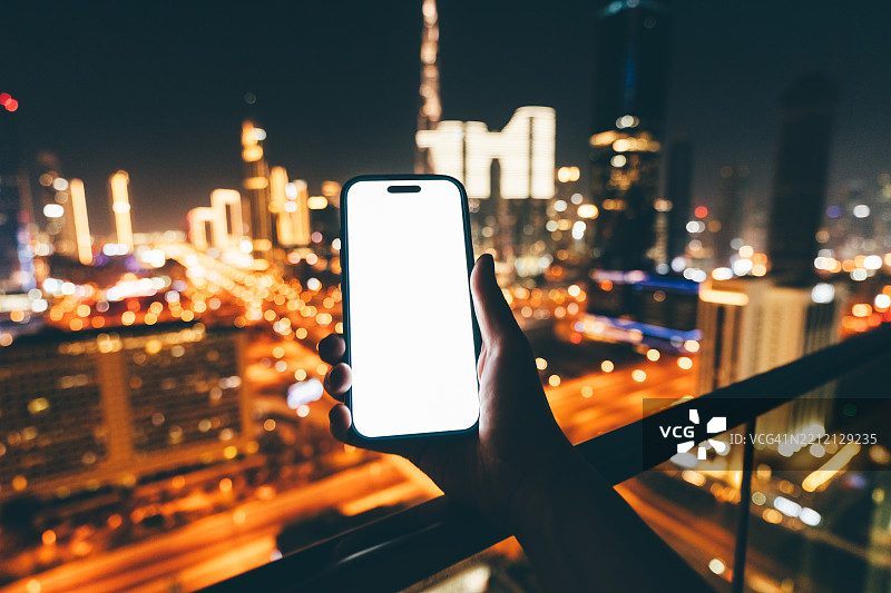 手握手机俯瞰城市。图片素材