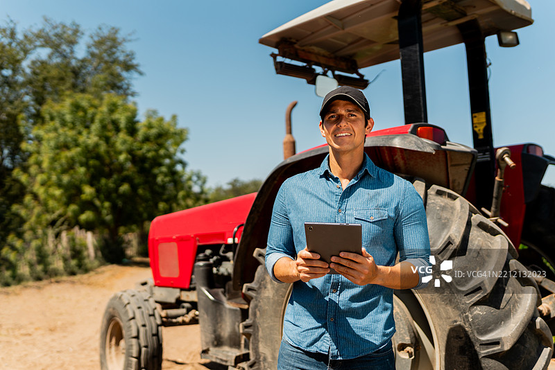 中年农民在农田里使用数字平板电脑的肖像图片素材