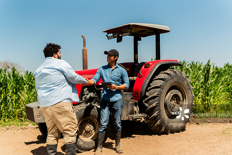 农民在农田里打招呼和交谈图片素材