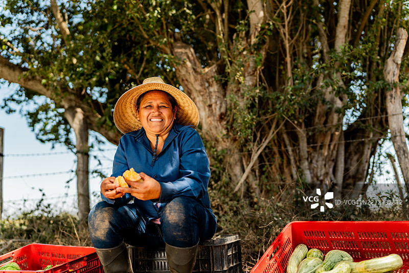 成熟农妇在农场休息时剥橘子的肖像图片素材